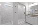 Bright bathroom features a frameless shower, marble tile, vanity with sink, and stylish lighting at 711 Virginia Ave, Raleigh, NC 27604