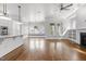 Open-concept living area with hardwood floors, a ceiling fan, and large windows at 711 Virginia Ave, Raleigh, NC 27604