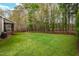 Expansive backyard featuring lush green grass and mature trees, providing privacy and a serene outdoor space at 7252 Bedford Ridge Dr, Apex, NC 27539