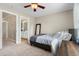 Well-lit bedroom featuring carpeted floors, a ceiling fan, and a doorway leading to an adjacent room at 7252 Bedford Ridge Dr, Apex, NC 27539