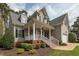 Inviting front exterior showcasing a covered porch, brick steps, and well-maintained landscaping around the property at 7252 Bedford Ridge Dr, Apex, NC 27539