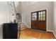 Bright foyer with hardwood floors, a staircase, and double doors allowing natural light to flood the entrance at 7252 Bedford Ridge Dr, Apex, NC 27539