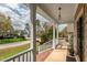 Covered front porch showcasing white railings, brick accents, and a view of the neighborhood street and surrounding homes at 7252 Bedford Ridge Dr, Apex, NC 27539