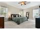 Bright main bedroom featuring a tray ceiling, large windows, neutral tones, and plush carpet at 7252 Bedford Ridge Dr, Apex, NC 27539
