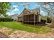 Home's exterior features a screened porch with a lush lawn, surrounded by mature trees and landscaping at 7252 Bedford Ridge Dr, Apex, NC 27539