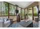 Relaxing screened porch featuring wicker furniture, a rustic barrel table, and views of the surrounding greenery at 7252 Bedford Ridge Dr, Apex, NC 27539