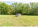 A quaint chicken coop sits on a sprawling lawn, surrounded by lush trees at 8079 Stone Heritage Rd, Middlesex, NC 27557