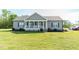 Lovely gray home with a classic white porch, black shutters, and manicured landscaping in a lush green yard at 8079 Stone Heritage Rd, Middlesex, NC 27557