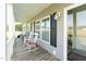 Inviting covered front porch with rocking chairs and a view of the expansive green lawn at 8079 Stone Heritage Rd, Middlesex, NC 27557