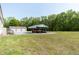 A backyard with a covered parking area, a garage, and well-maintained green grass at 8091 Stone Heritage Rd, Middlesex, NC 27557