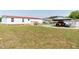 Back view of the home with a carport, a garage, and a well-maintained lawn at 8091 Stone Heritage Rd, Middlesex, NC 27557