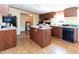 Open kitchen featuring an island, black appliances, wood cabinets, and wood-look flooring at 8091 Stone Heritage Rd, Middlesex, NC 27557
