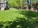 Expansive backyard with a manicured lawn, shade trees, and room for outdoor activities at 8300 Clarks Branch Dr, Raleigh, NC 27613