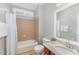Bright bathroom featuring a shower-tub combo, toilet, and vanity with decorative mirror and hardware at 8300 Clarks Branch Dr, Raleigh, NC 27613