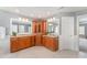 Bathroom with wood cabinets, dual sinks, granite countertops, and large mirrors for a luxurious feel at 8300 Clarks Branch Dr, Raleigh, NC 27613