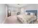 Inviting bedroom with a blue upholstered headboard, patterned quilt, and neutral decor for a serene feel at 8300 Clarks Branch Dr, Raleigh, NC 27613