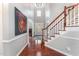 Bright foyer with hardwood floors, a staircase, and elegant architectural details at 8300 Clarks Branch Dr, Raleigh, NC 27613