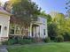 Charming home with stone and shingle siding, a well-manicured lawn, and colorful landscaping at 8300 Clarks Branch Dr, Raleigh, NC 27613