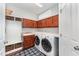 Functional laundry room with ample cabinetry, counter space, and modern appliances at 8300 Clarks Branch Dr, Raleigh, NC 27613