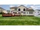 A lush backyard with manicured lawn, wooden deck, and attractive two-story home with arched windows for natural light at 9201 Club Hill Dr, Raleigh, NC 27617