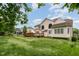 Expansive backyard with green lawn, patio, mature trees, and a well-maintained home with large windows at 9201 Club Hill Dr, Raleigh, NC 27617