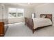 A well-lit bedroom with a neutral color palette, featuring a comfortable bed and a large window at 9201 Club Hill Dr, Raleigh, NC 27617
