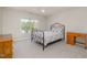 Bright bedroom with a wrought iron bed frame, natural light, neutral walls, and carpet flooring at 9201 Club Hill Dr, Raleigh, NC 27617