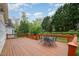 A spacious wooden deck features a table and chairs, overlooking the lush backyard and vibrant green trees at 9201 Club Hill Dr, Raleigh, NC 27617