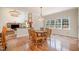 Cozy dining space adjacent to living room with hardwood floors, chandelier and window views at 9201 Club Hill Dr, Raleigh, NC 27617