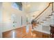 Bright and airy foyer with hardwood floors, grand staircase, and elegant chandelier at 9201 Club Hill Dr, Raleigh, NC 27617
