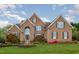 Traditional brick home with a manicured lawn, fountain, and beautiful landscaping at 9201 Club Hill Dr, Raleigh, NC 27617