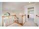 A well-lit hallway with elegant staircase and chandelier, leading to an open doorway and windowed room at 9201 Club Hill Dr, Raleigh, NC 27617