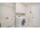 A bright laundry room featuring modern washer and dryer, practical storage cabinets, and a utility sink at 9201 Club Hill Dr, Raleigh, NC 27617