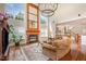 Sunlit living room with fireplace, chandelier, hardwood floors, and comfortable seating at 9201 Club Hill Dr, Raleigh, NC 27617