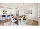 View of the dining area showcases a rustic wood table, stylish chairs, chandelier, and seamlessly connects to the kitchen at 1003 Canary Pepper Dr, Durham, NC 27713