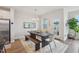 Bright dining area features a rustic wood table, bench, stylish chairs, and natural light from the door to the balcony at 1003 Canary Pepper Dr, Durham, NC 27713