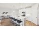 A bright kitchen features a center island with barstool seating, white cabinets, modern appliances, and pendant lighting at 1003 Canary Pepper Dr, Durham, NC 27713