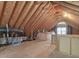 Spacious unfinished attic featuring exposed rafters, duct work, and natural light from the window at 1008 Brittley Way, Apex, NC 27502
