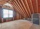 Bright unfinished attic space features a window, wooden beams, and wood paneled walls at 1008 Brittley Way, Apex, NC 27502