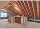 Spacious unfinished attic space features a window and wooden beams at 1008 Brittley Way, Apex, NC 27502