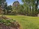 A view of the backyard showing a sprawling green lawn, landscaping and fencing at 1008 Brittley Way, Apex, NC 27502