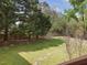 Serene backyard view featuring mature trees and a wooden fence at 1008 Brittley Way, Apex, NC 27502