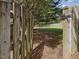 View through an opened wooden gate into a large backyard at 1008 Brittley Way, Apex, NC 27502