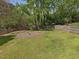 Beautiful backyard with green grass, mature trees, and a wooden fence surrounding the property at 1008 Brittley Way, Apex, NC 27502