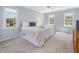 Bright bedroom with three windows, neutral walls, carpet, and a comfortable king-sized bed at 1008 Brittley Way, Apex, NC 27502