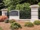 Haddon Hall entrance sign is beautifully landscaped with lush greenery, flowers, and stone pillars creating an inviting community at 1008 Brittley Way, Apex, NC 27502