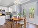 Cozy dining area featuring a wooden table set and French doors to deck, with updated kitchen cabinets at 1008 Brittley Way, Apex, NC 27502