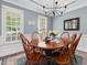 Bright dining room with classic decor, blue walls, elegant chandelier, and views of the front yard at 1008 Brittley Way, Apex, NC 27502