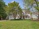 Traditional two-story home with a lush green lawn, red shutters, and a charming covered front porch at 1008 Brittley Way, Apex, NC 27502