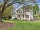 Charming two-story home features a welcoming front porch, red shutters, attached garage, and lush lawn at 1008 Brittley Way, Apex, NC 27502